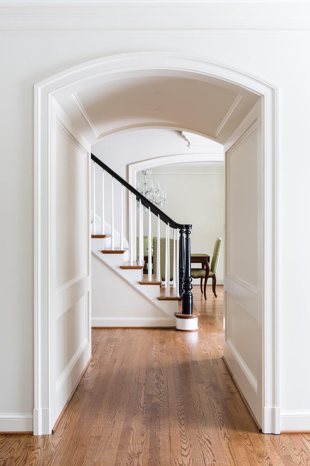 Custom hall archway and artisanal black paint finish on stairs