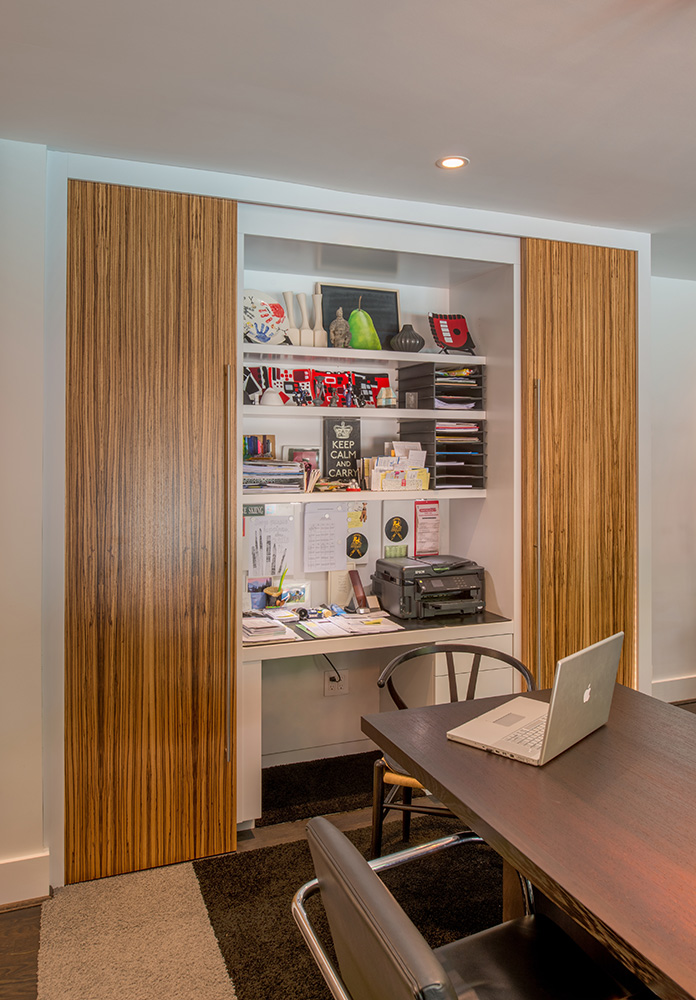 Sliding doors in striking zebrawood conceal an office niche