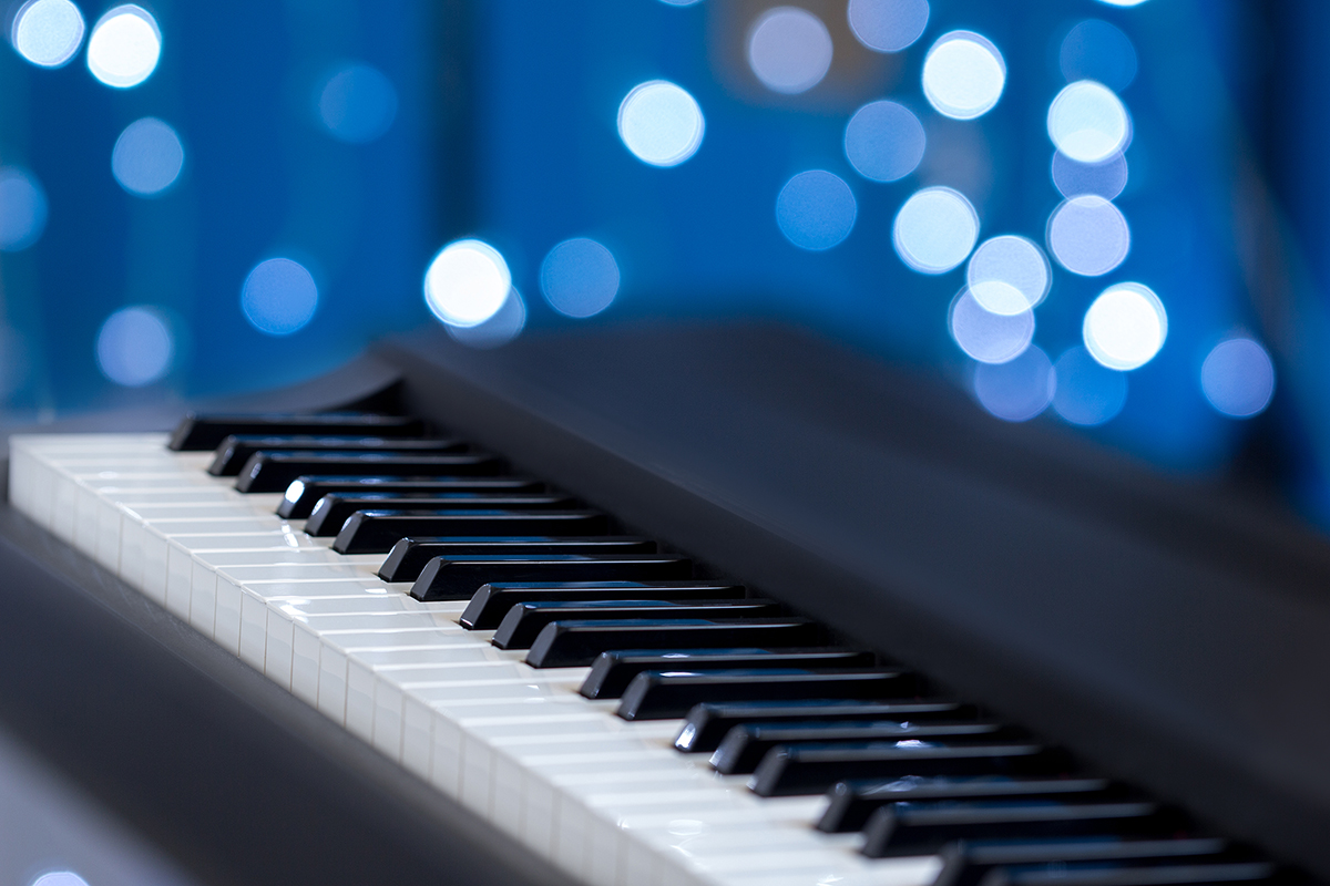 Piano keys side view with shallow depth of field on a blue bokeh background